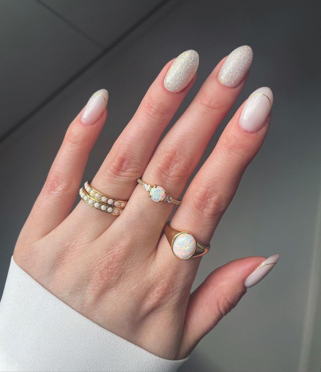 bride with almond shaped classy wedding nails with gold tip details on the pinky pointer and thumb and glitter on the ring and middle fingers