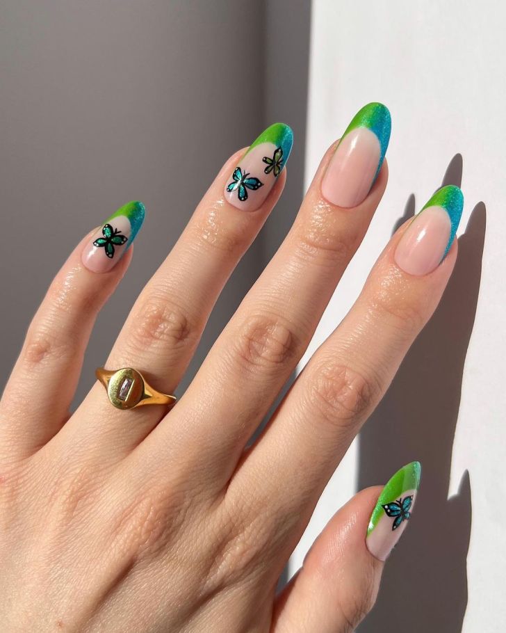 blue and green ombre French tip Taylor Swift nails with a butterfly design inspired by the debut album on the Eras Tour