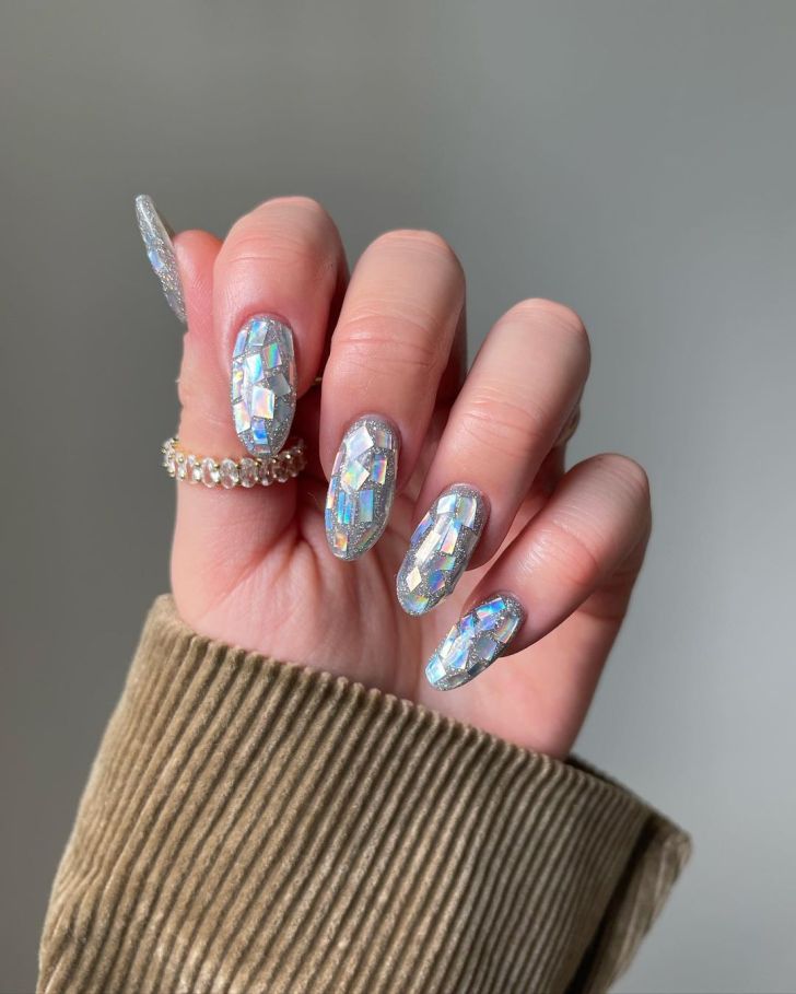 glittery silver manicure with a 3D disco mirrorball Folklore era design