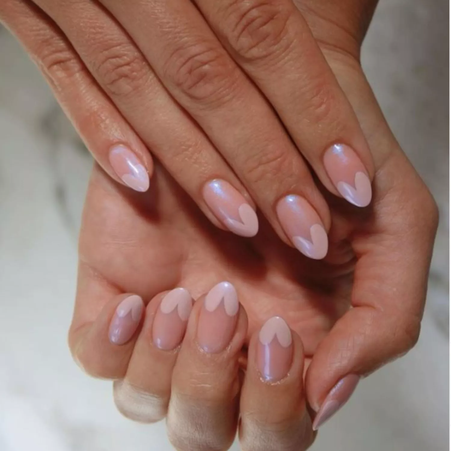 Glazed, glossy pink nails with heart tips.