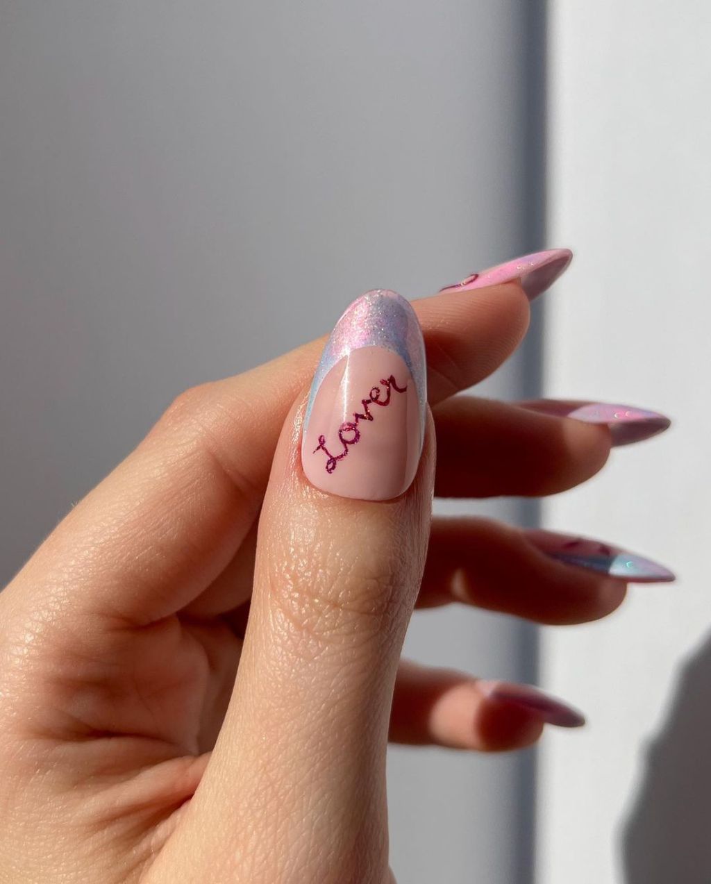 iridescent French tip Taylor Swift nails with glittery pink cursive lettering design inspired by the Lover album on the Eras Tour