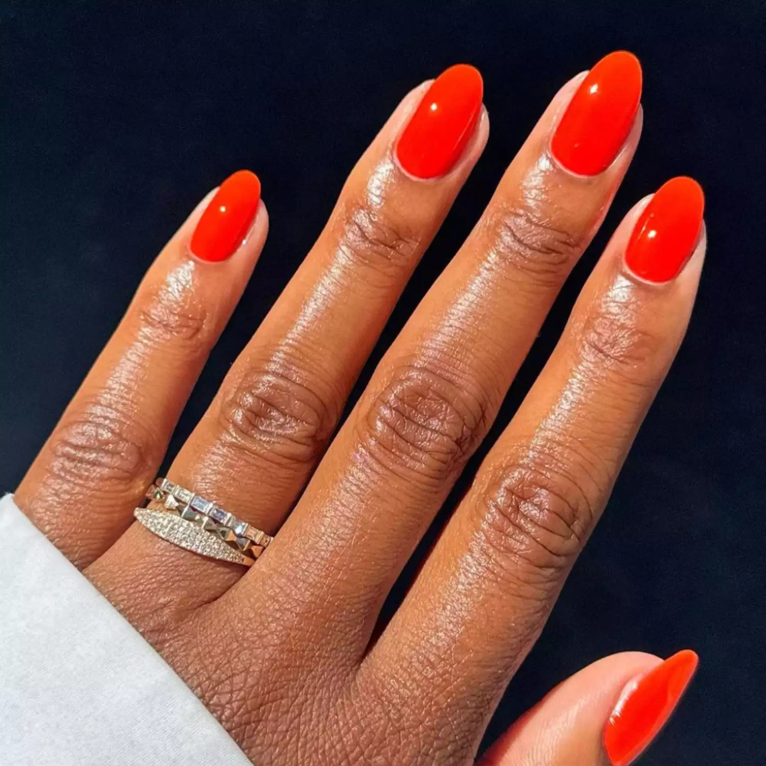 A bright red manicure against a dark background