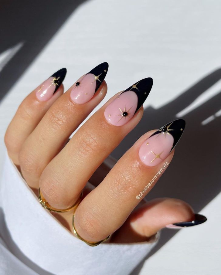 long black and gold french tip new years nails with celestial nail art