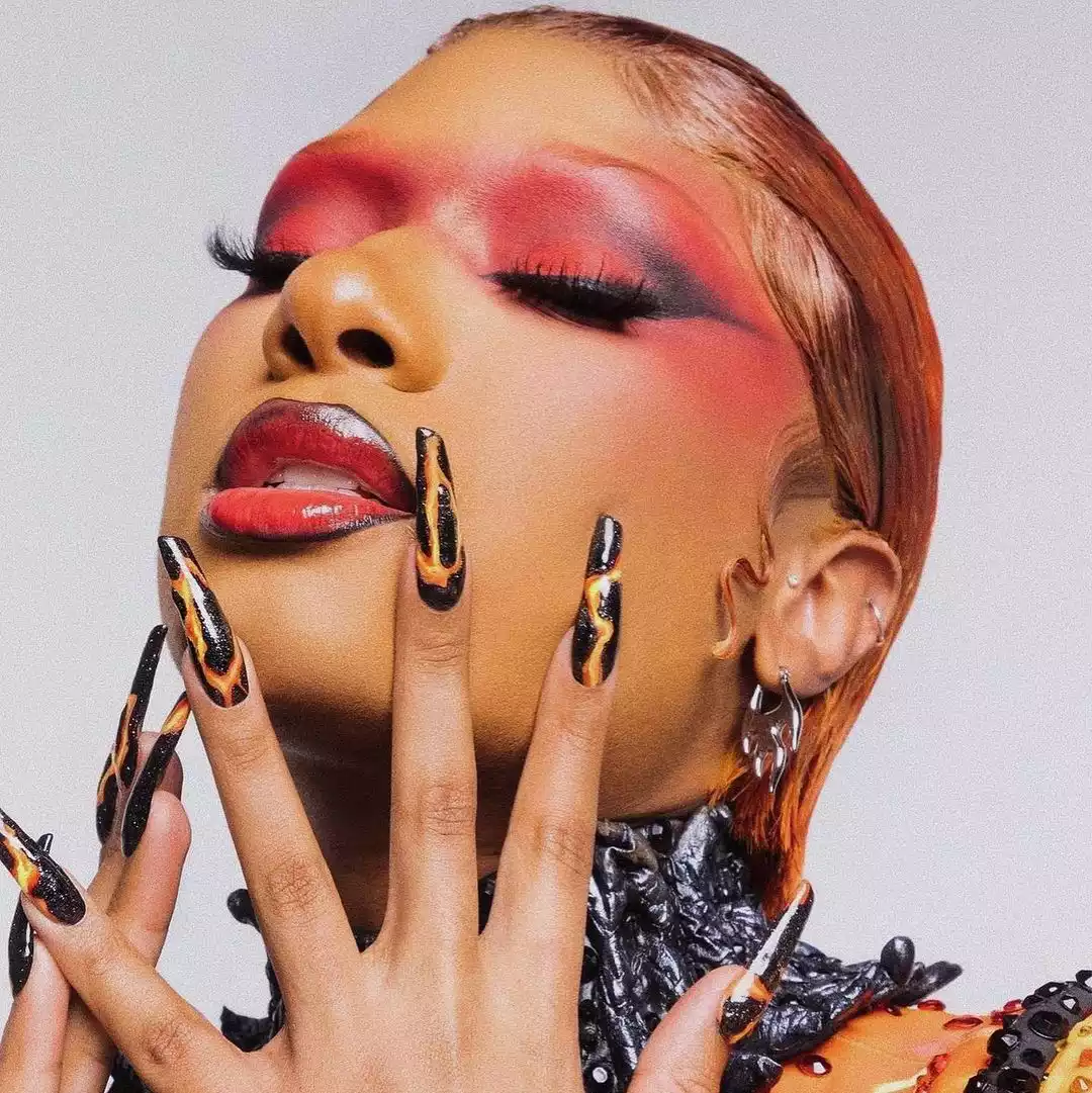 black and orange fire nails on megan thee stallion