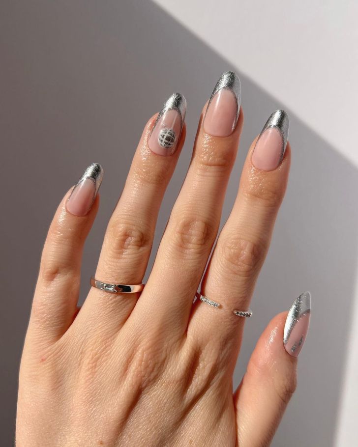 metallic silver French tip Taylor Swift nails with a mirrorball design on one finger inspired by the Folklore album on the Eras Tour