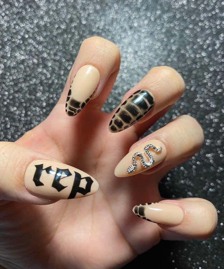 mismatched press on Taylor Swift nails with snakeskin and French tip designs inspired by the Reputation album of the Eras Tour