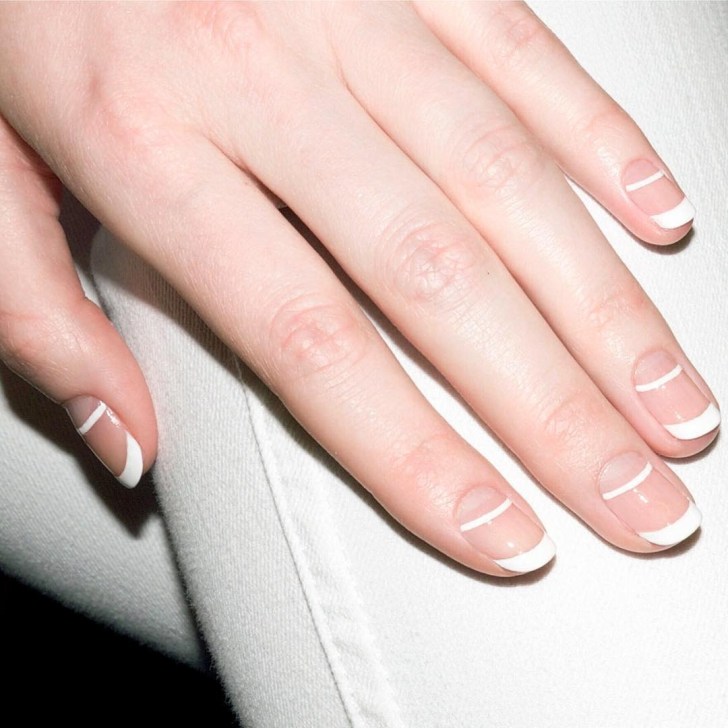 bride displaying her double white line French manicure classy wedding nails