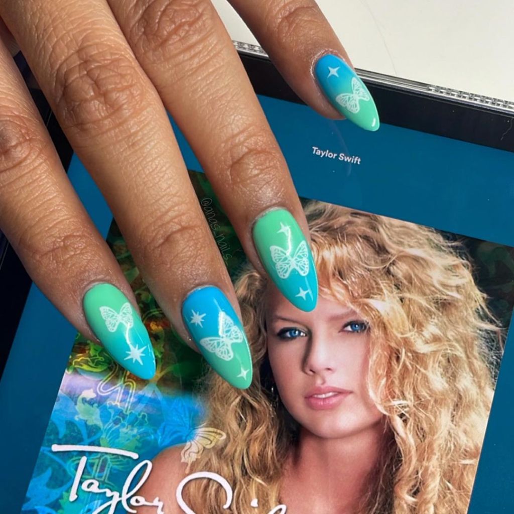 ombre blue and green Taylor Swift nails with a cute butterfly design inspired by the debut album on the Eras Tour