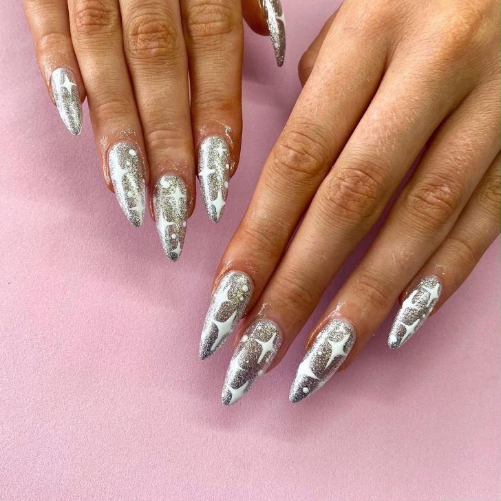 pointed glitter silver new years nails with white celestial designs