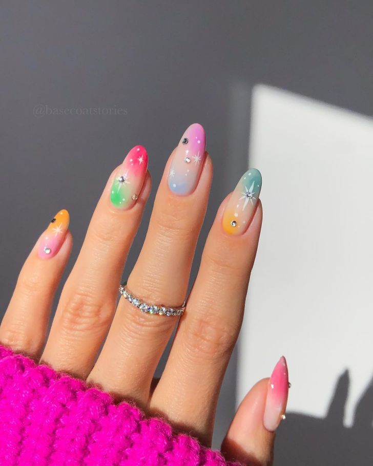 rainbow mismatched aura nails with a celestial design and rhinestone details