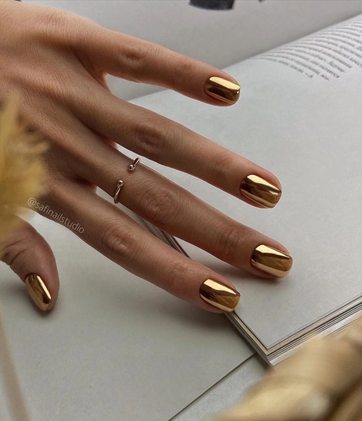 hand displaying a short metallic gold wedding manicure