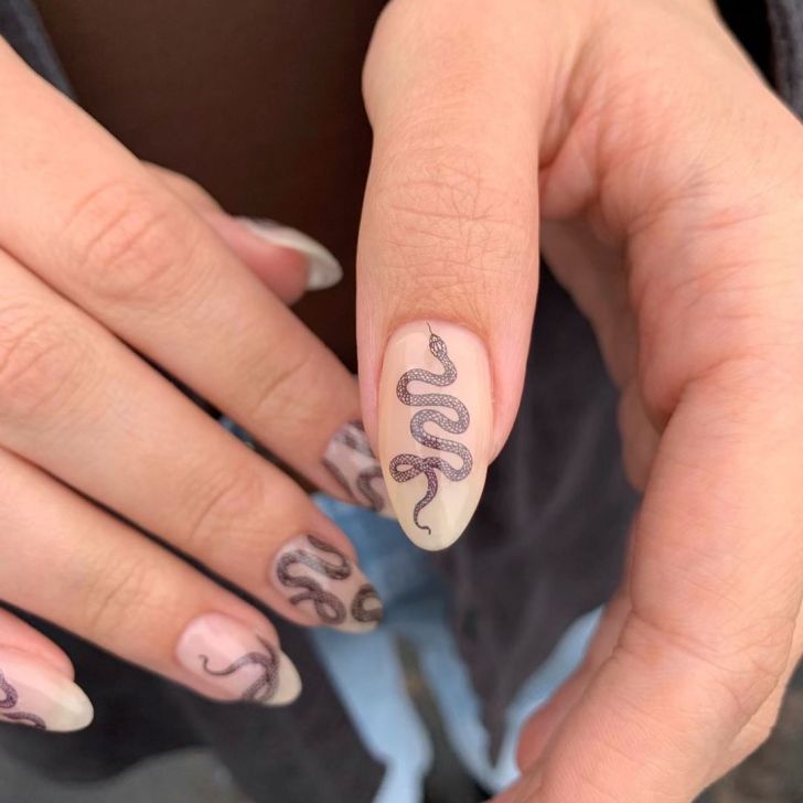 simple nude Taylor Swift Eras tour nails with an illustrated fine line snake design inspired by the Reputation album