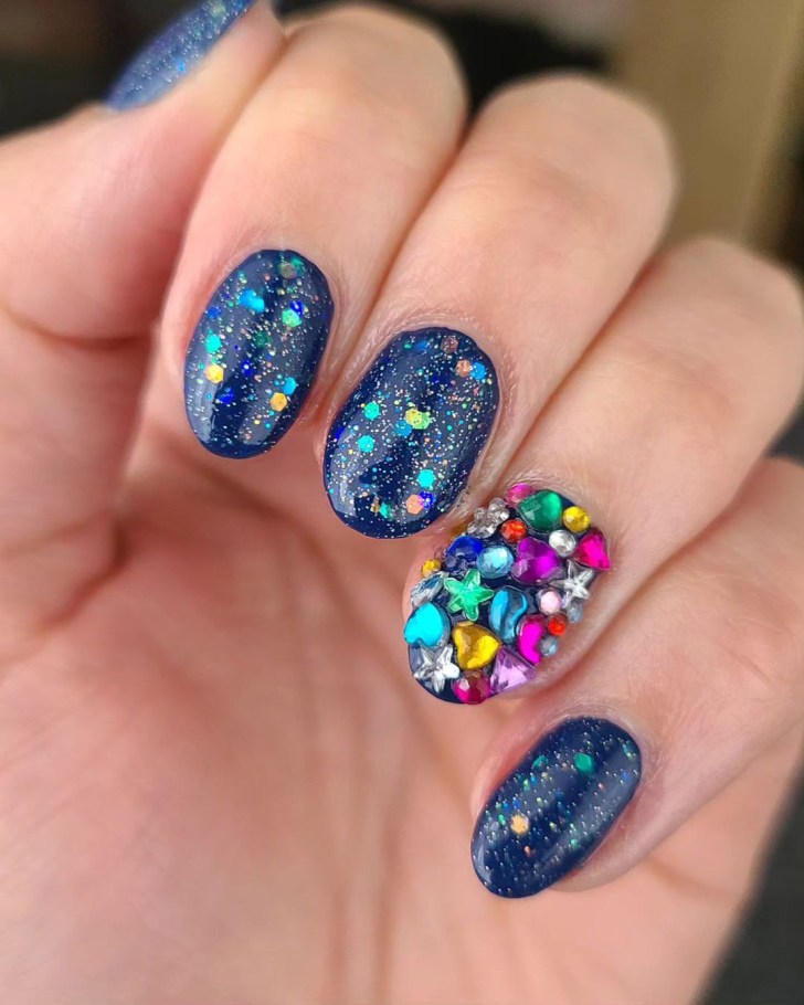 sparkly blue Taylor Swift Eras tour nails with a 3D rhinestone design inspired by the Bejeweled song and Midnights album