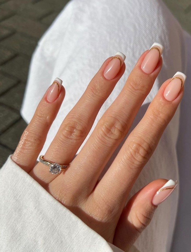 bride wearing square double french tip gold white wedding nails