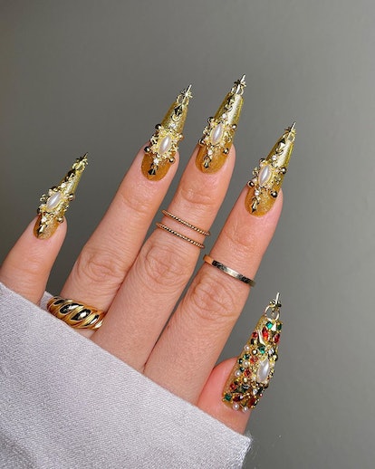 Decadent gold chrome nails with gilded gems and pearls match the mob wife aesthetic.