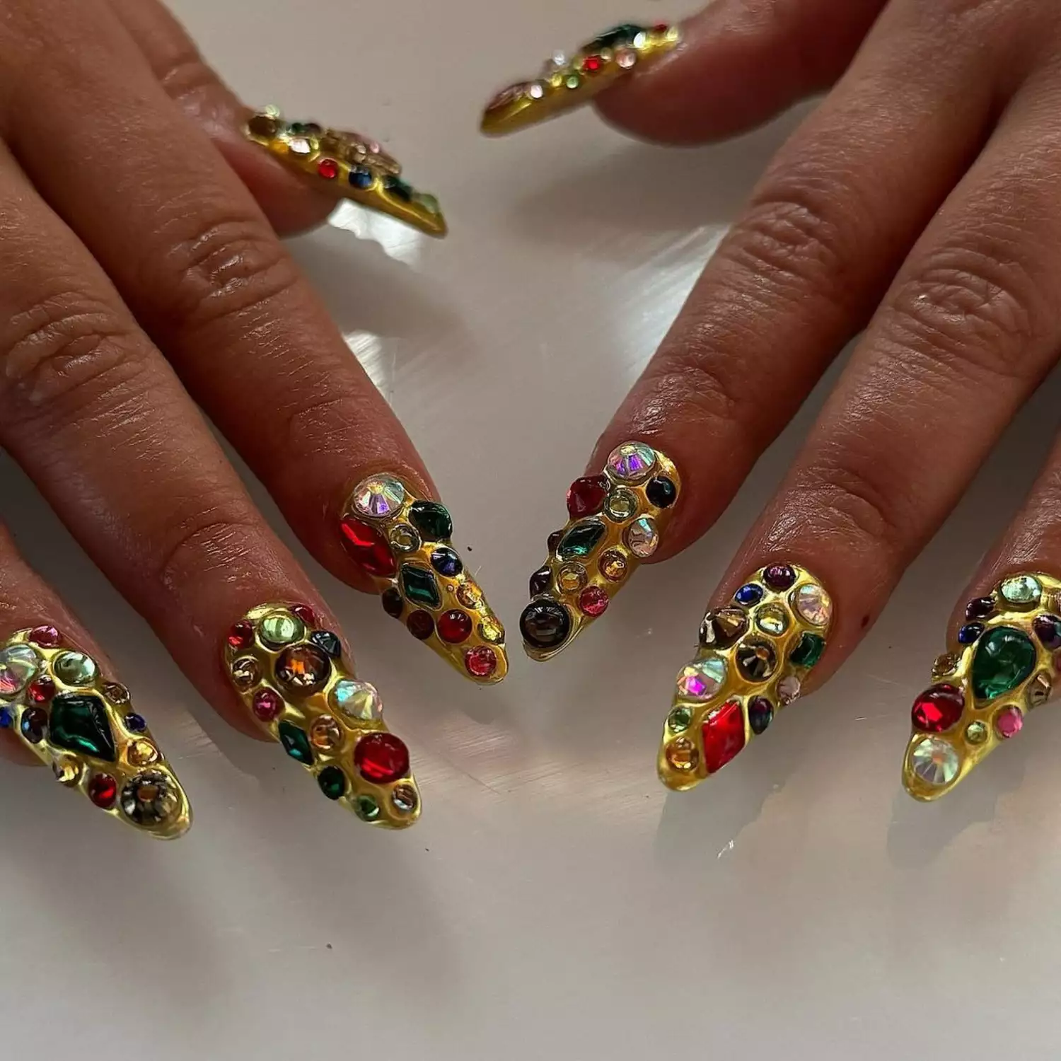 Gold chrome nails with many 3D gemstone accents