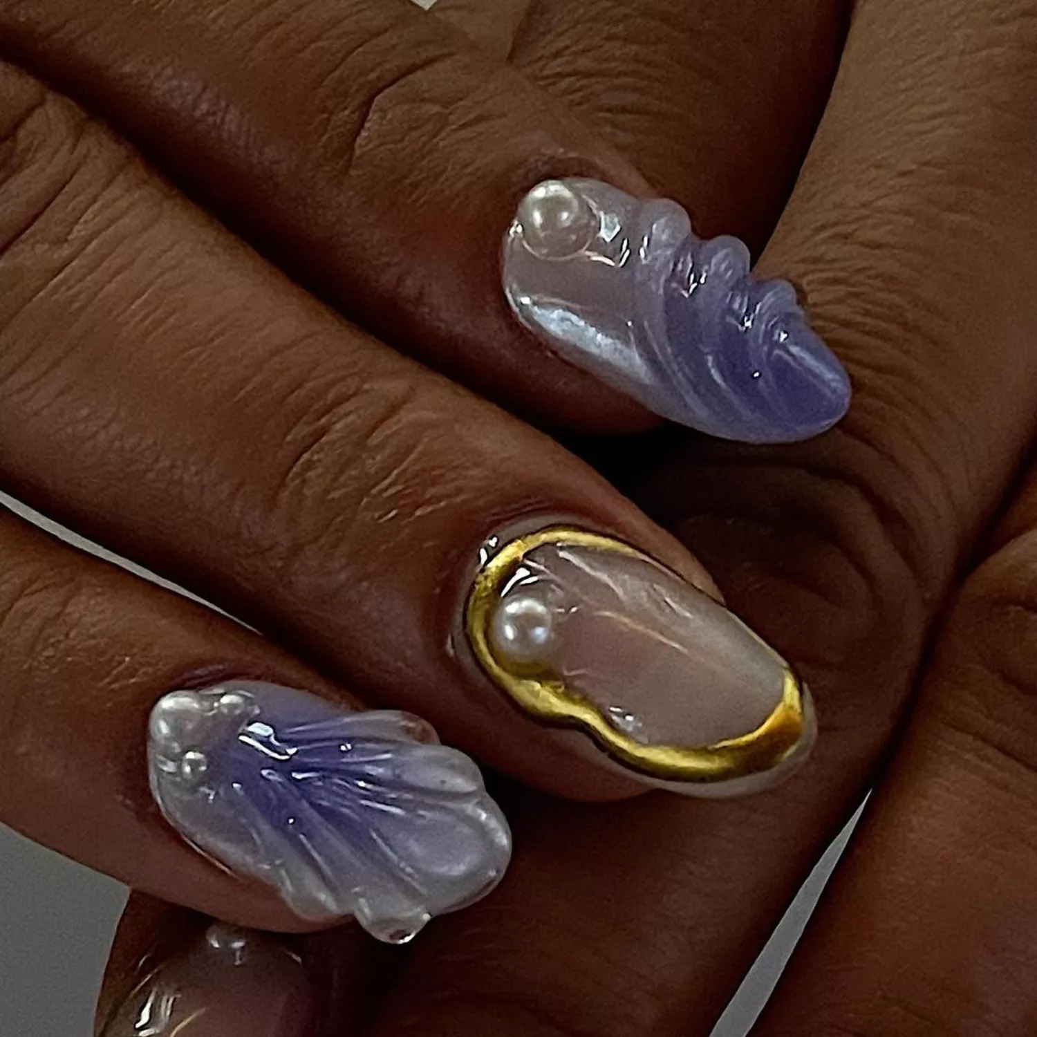 Translucent manicure with 3D pearl, oyster, and scale accents