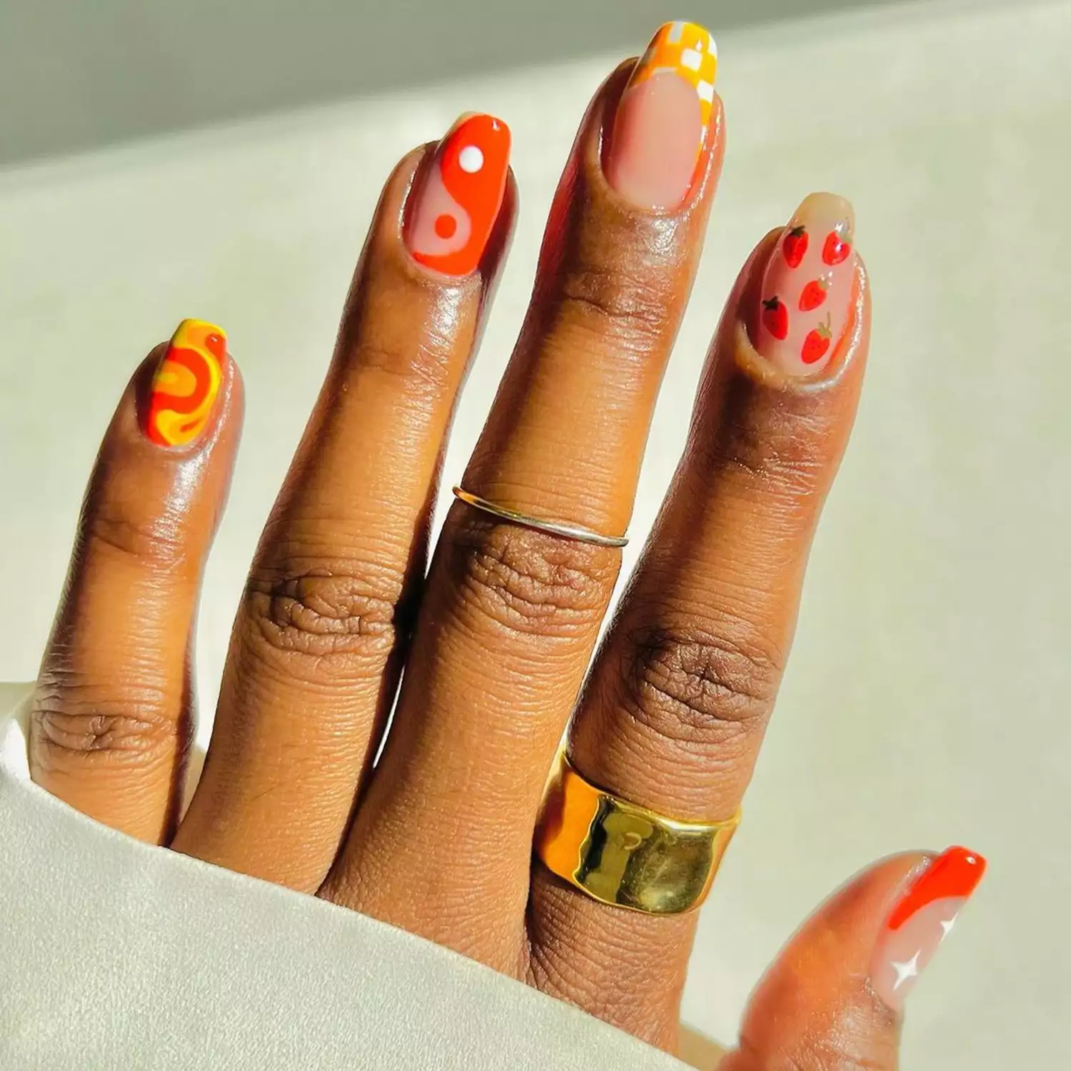 '70s-Inspired Mismatch Mani in shades of yellow, orange, and red