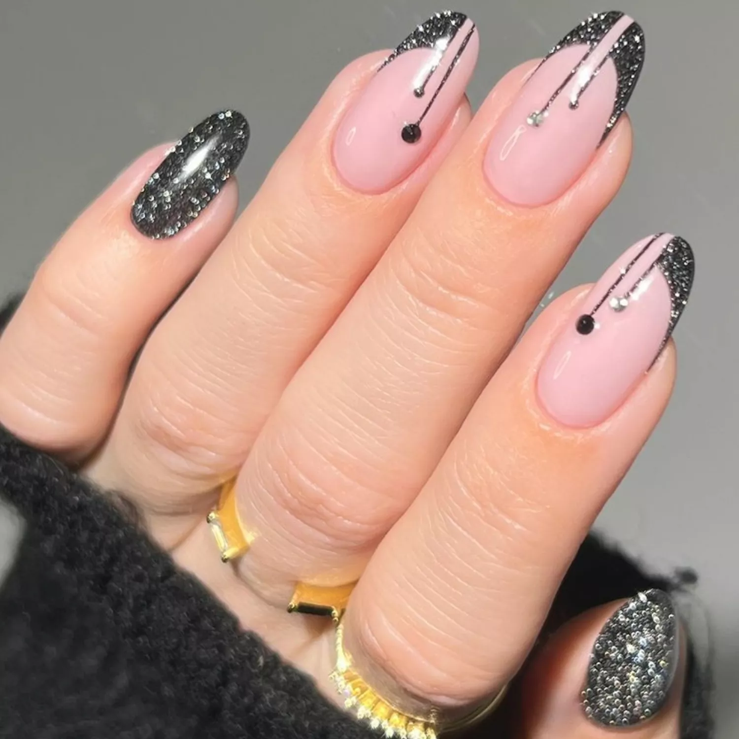 Manicure with pale pink base and black glitter French tip drip design