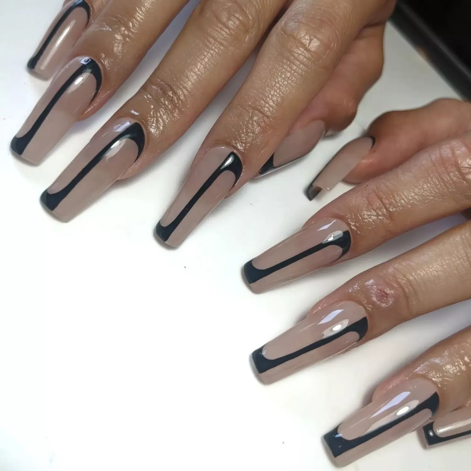 Nude long nails with thin black linear nail art