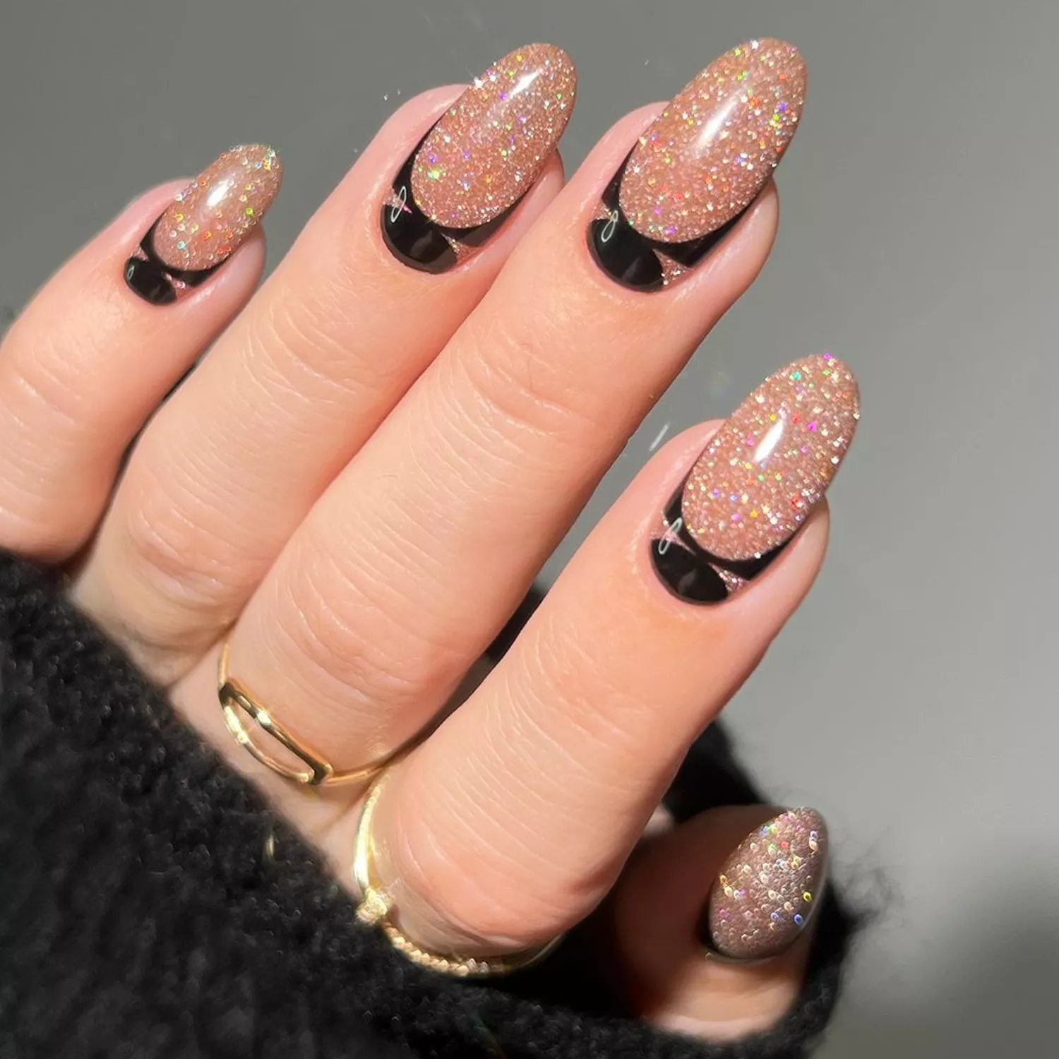 Manicure with champagne gold glitter base and black art deco cuticle design