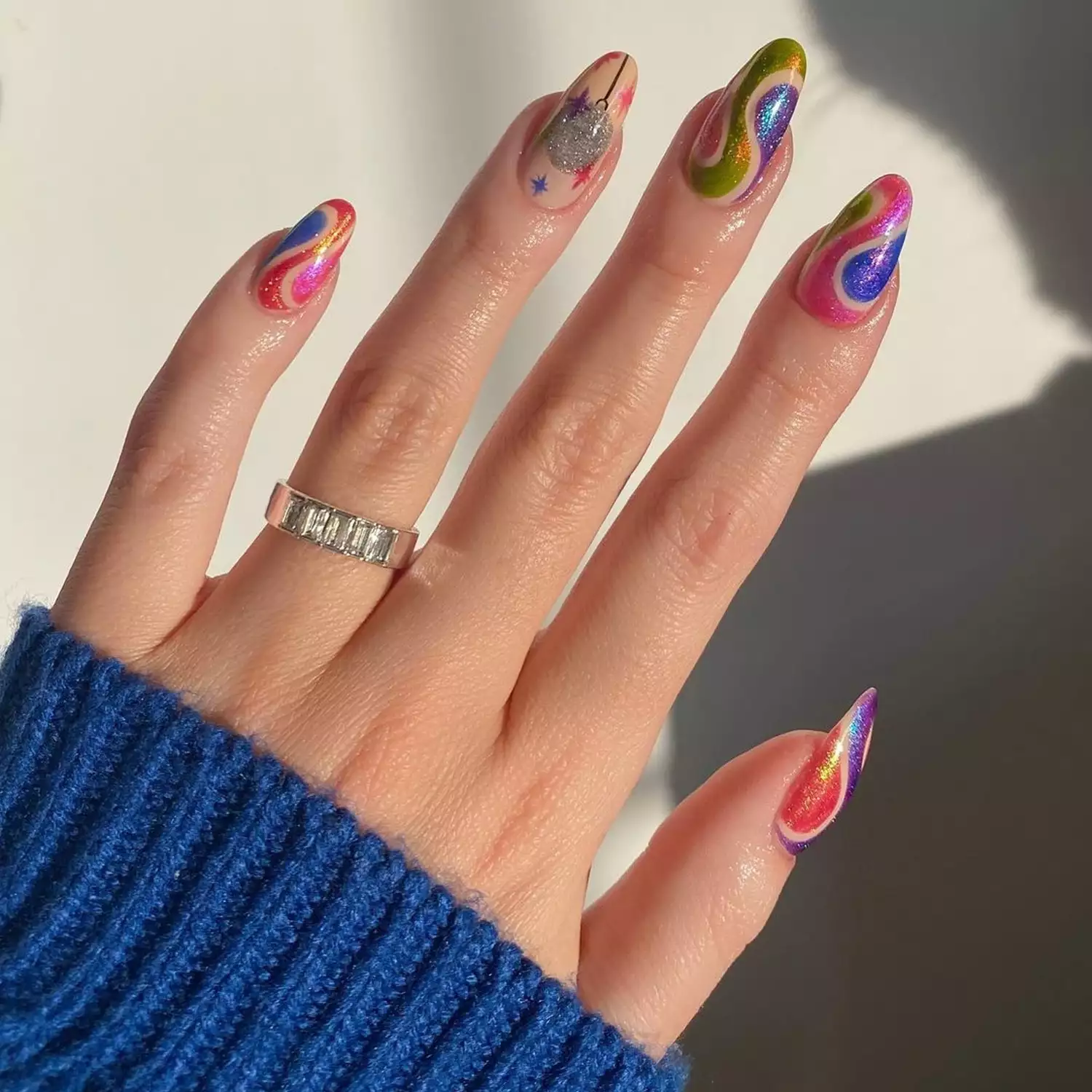 Shimmery multicolored swirl nails with a disco ball accent nail