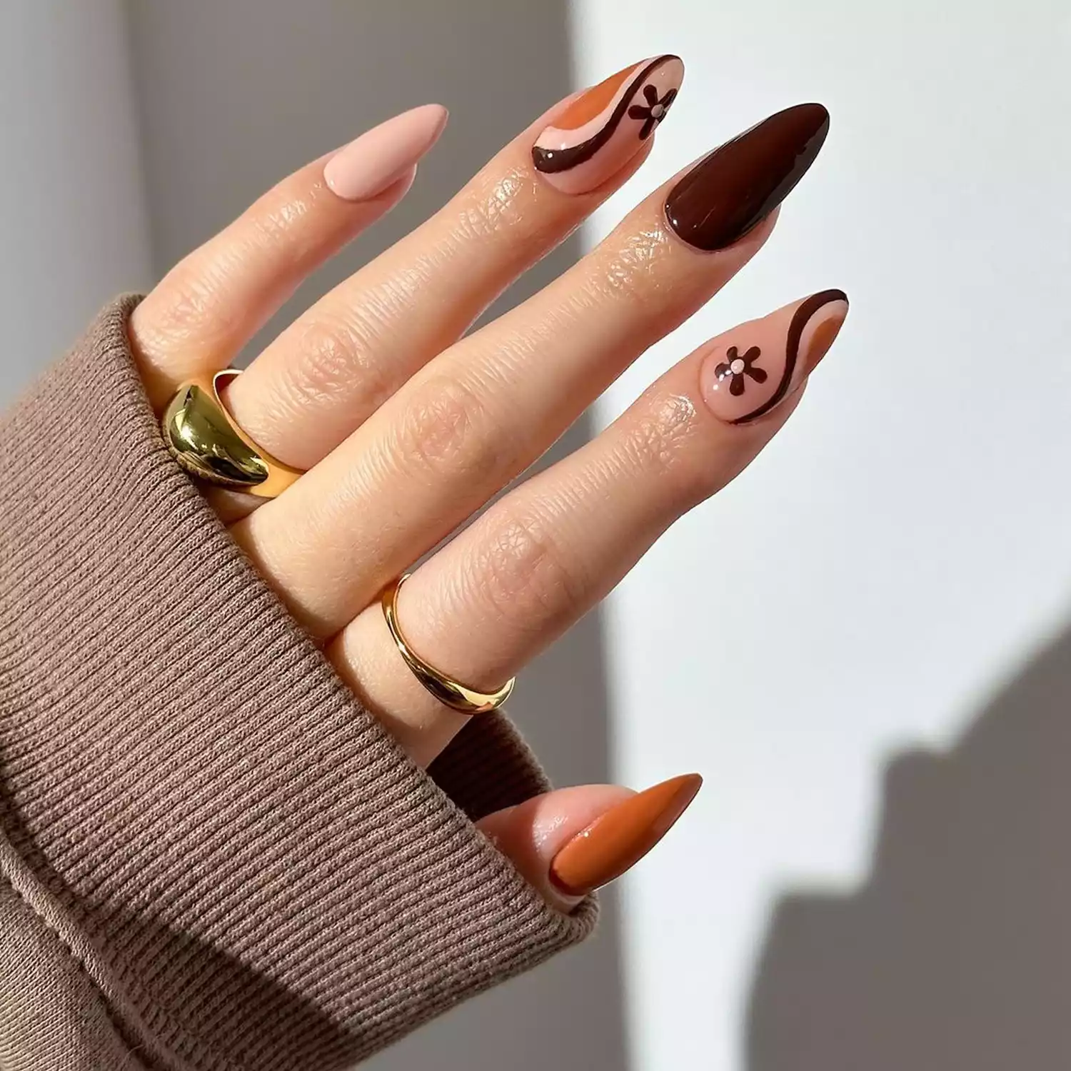 Multicolored brown swirl nails with flower accents