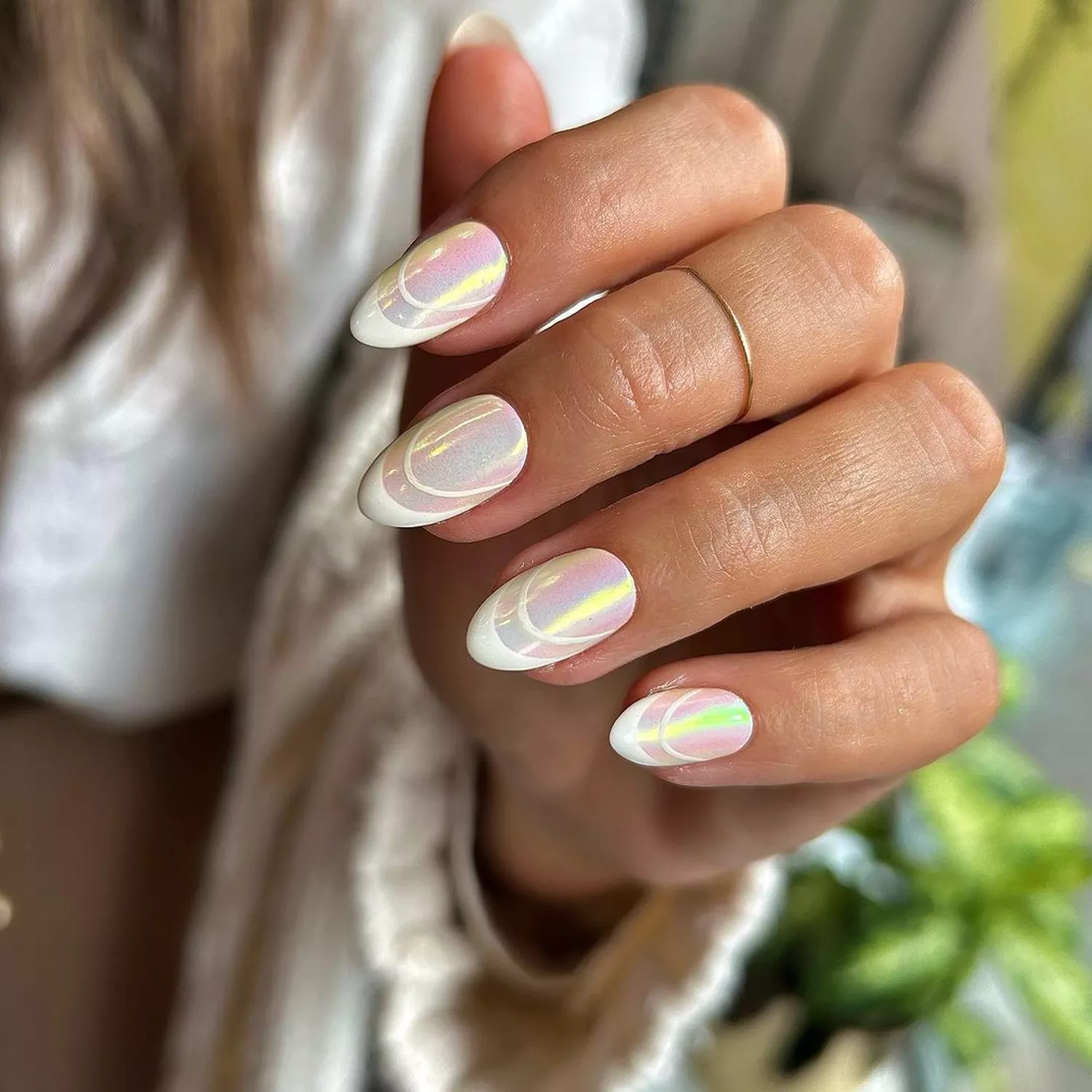 Close-up of manicure with holographic base and pearlescent art deco French tips