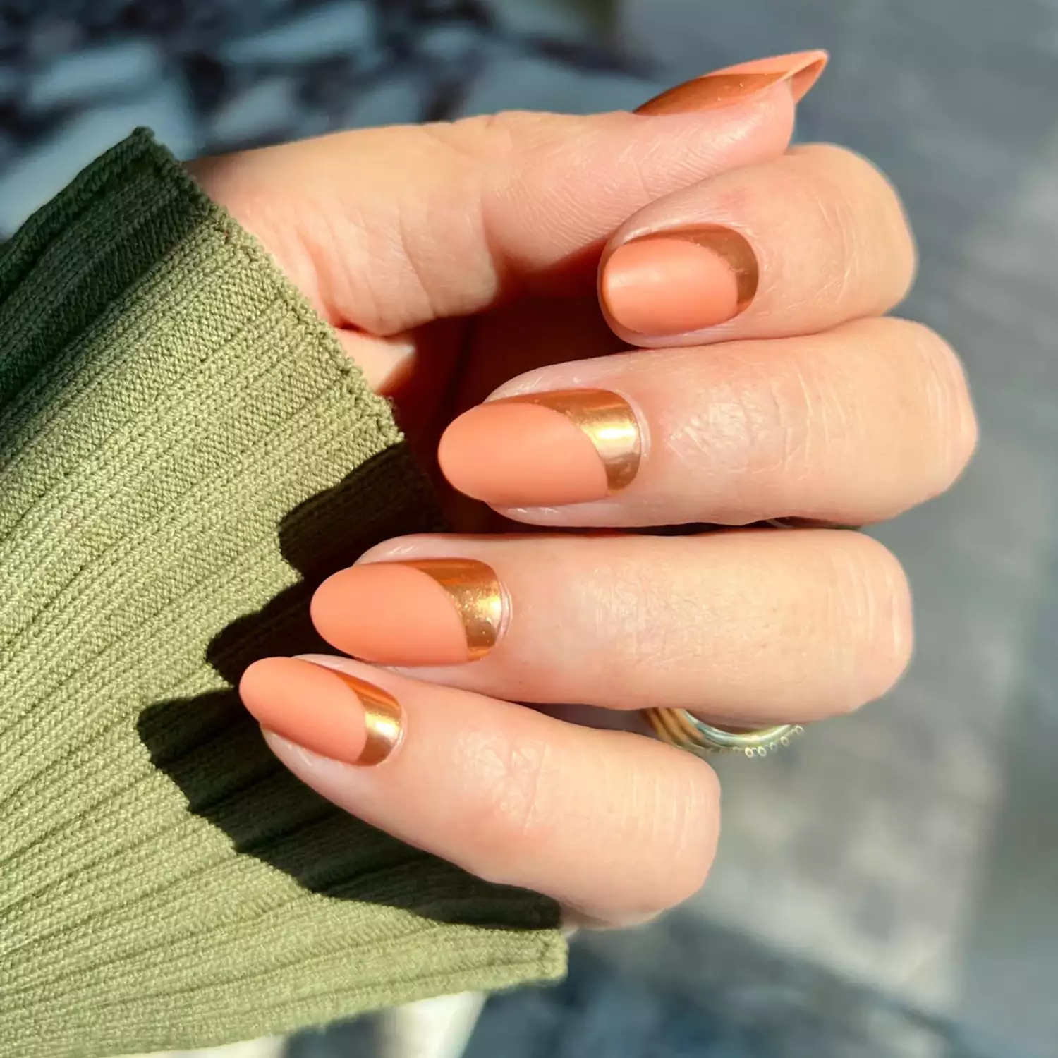 Manicure with matte peach base and gold sweeping curve design