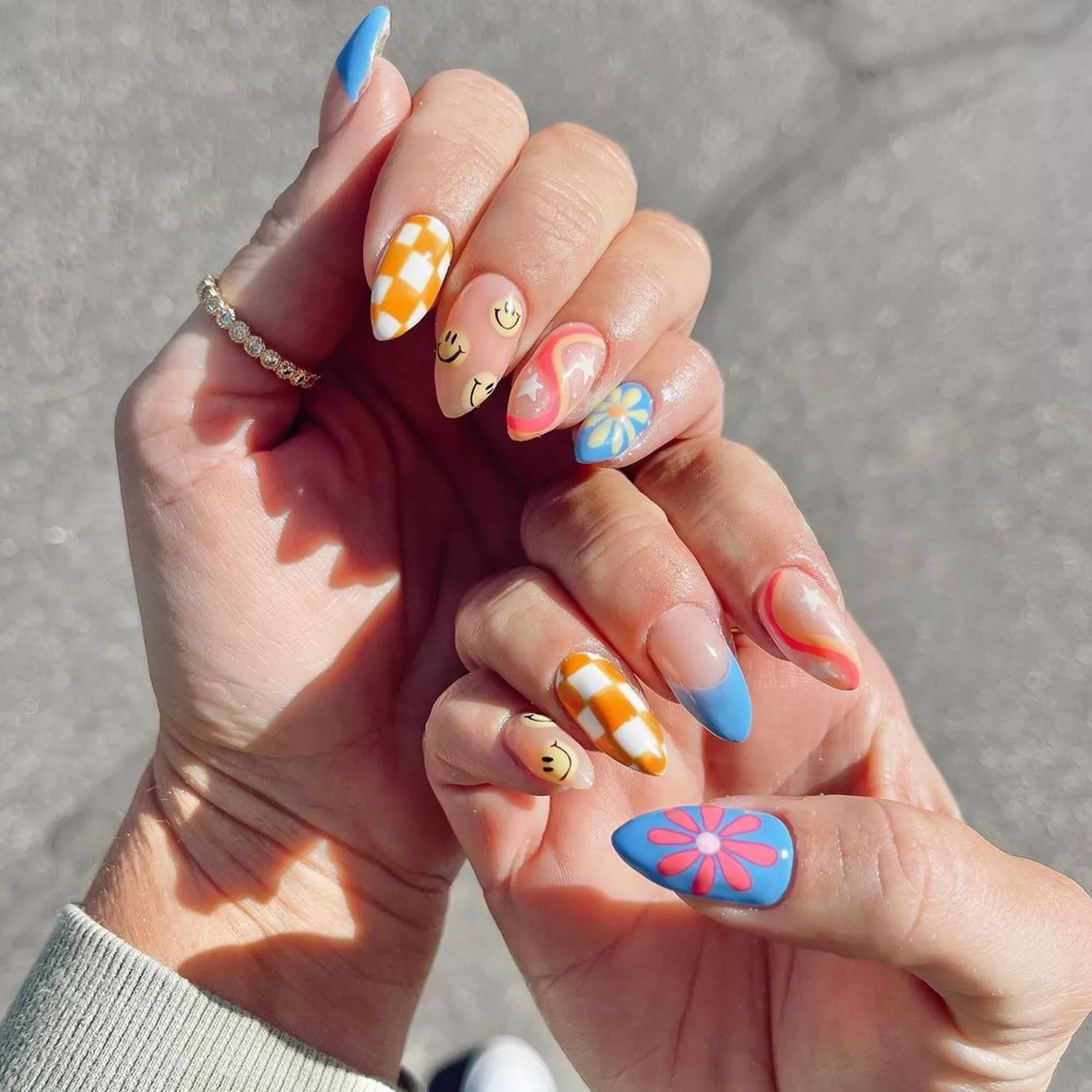 Pastel '70s Nails with checkers, swirls, flowers, and smiley faces 