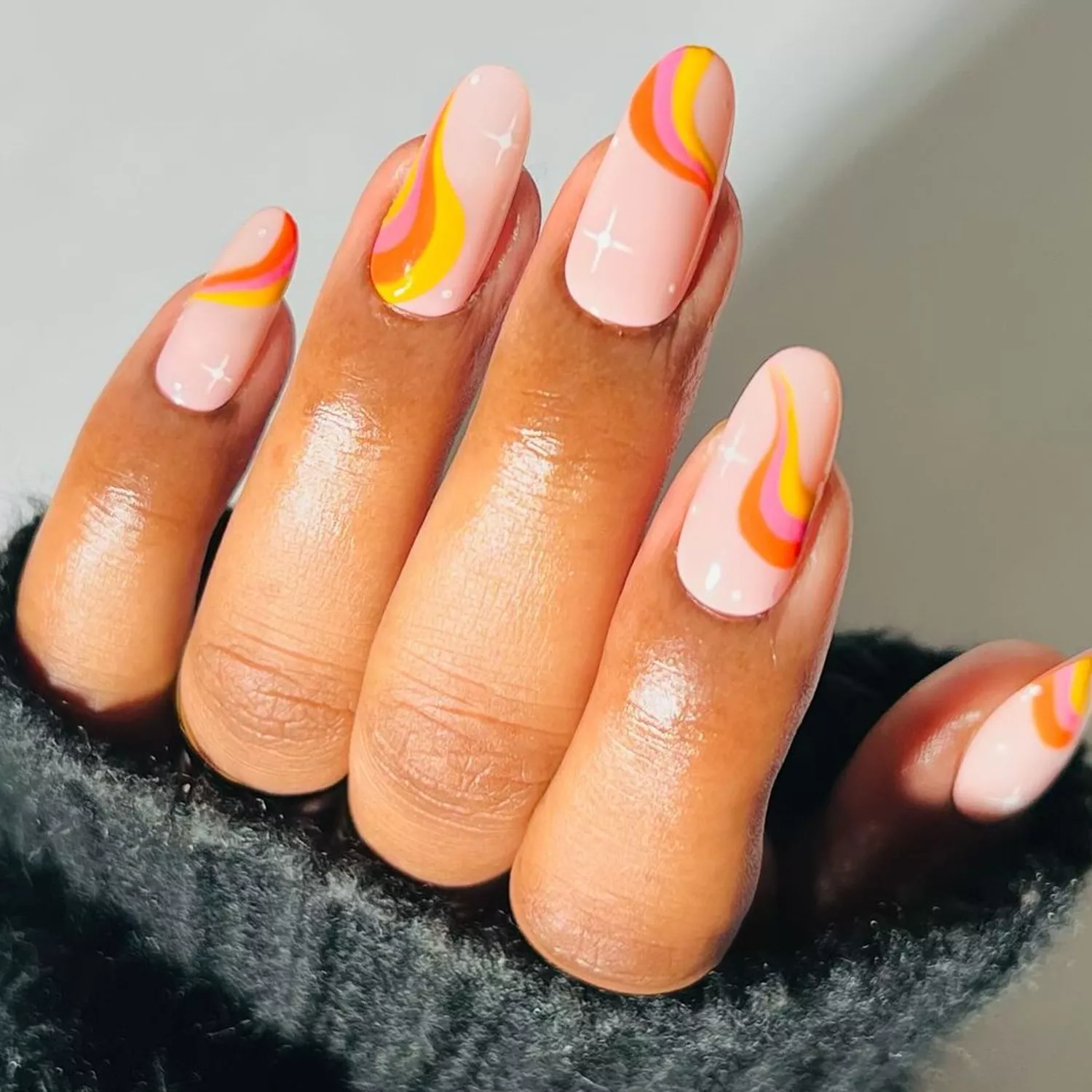 Warm-toned yellow, pink, and orange swirl nails