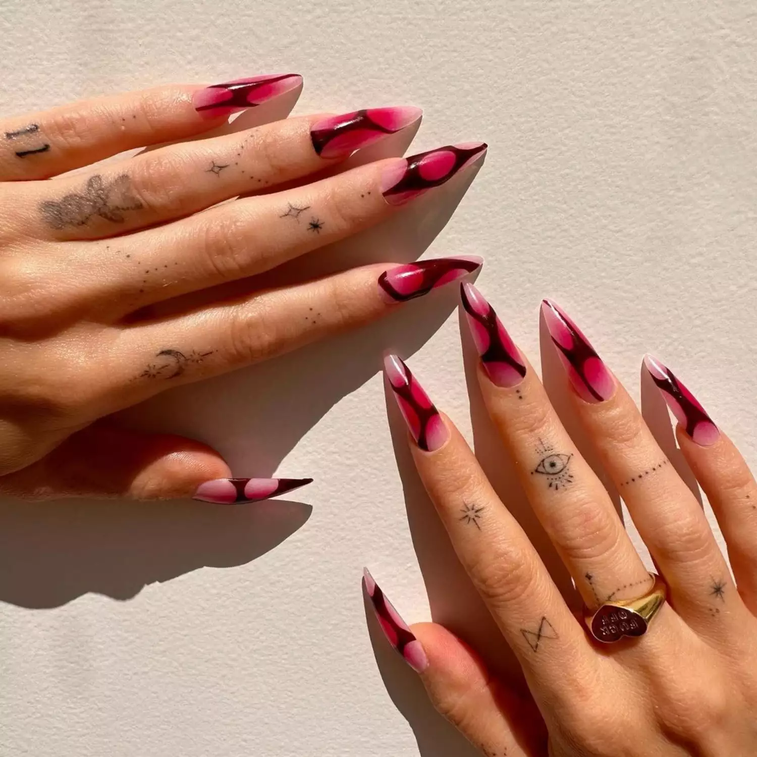 Black and pink aura nails with tattoos