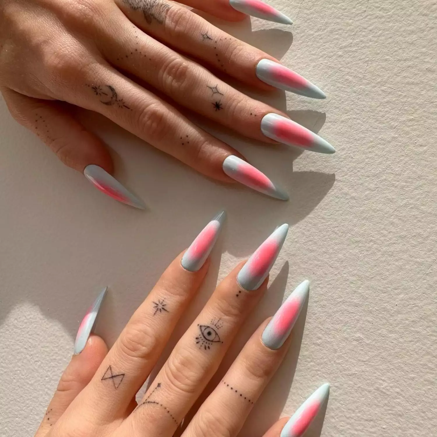 Baby blue and pink aura long pointy nails with tattoos