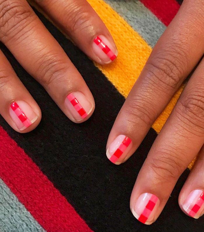 Two hands with red stripe manicure