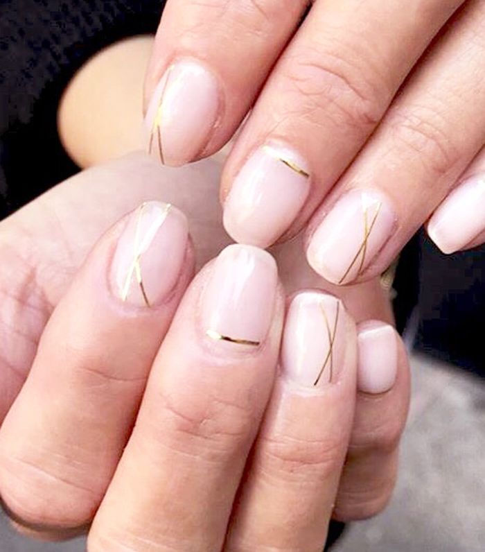 Two hands with minimal gold line manicure