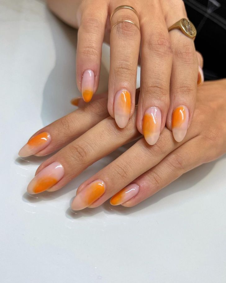 citrus orange almond shaped aura nails design on a clear gloss base coat