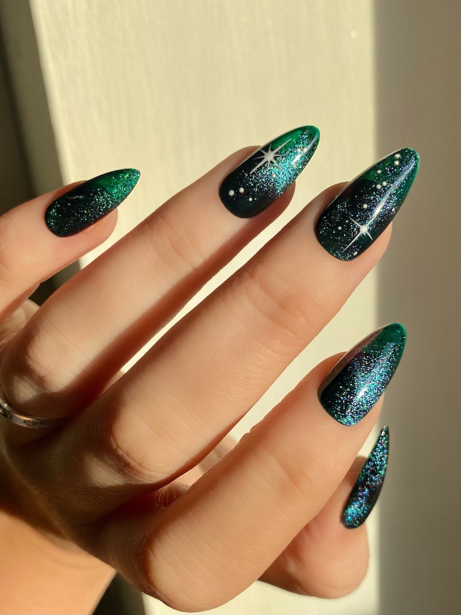 Black and green galaxy cat eye nails with stars