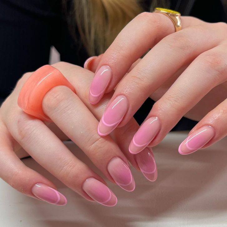 long blush color aura nails with a pink French tip outline