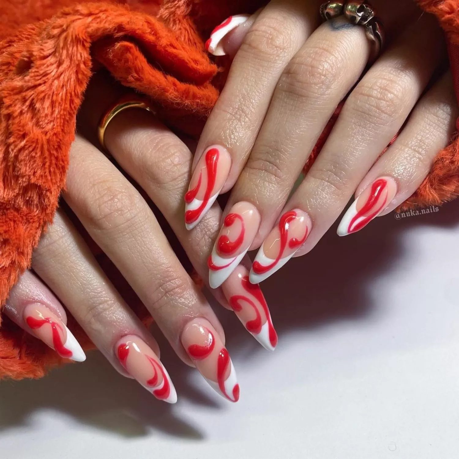 French manicure with red 3D swirls and orange coat