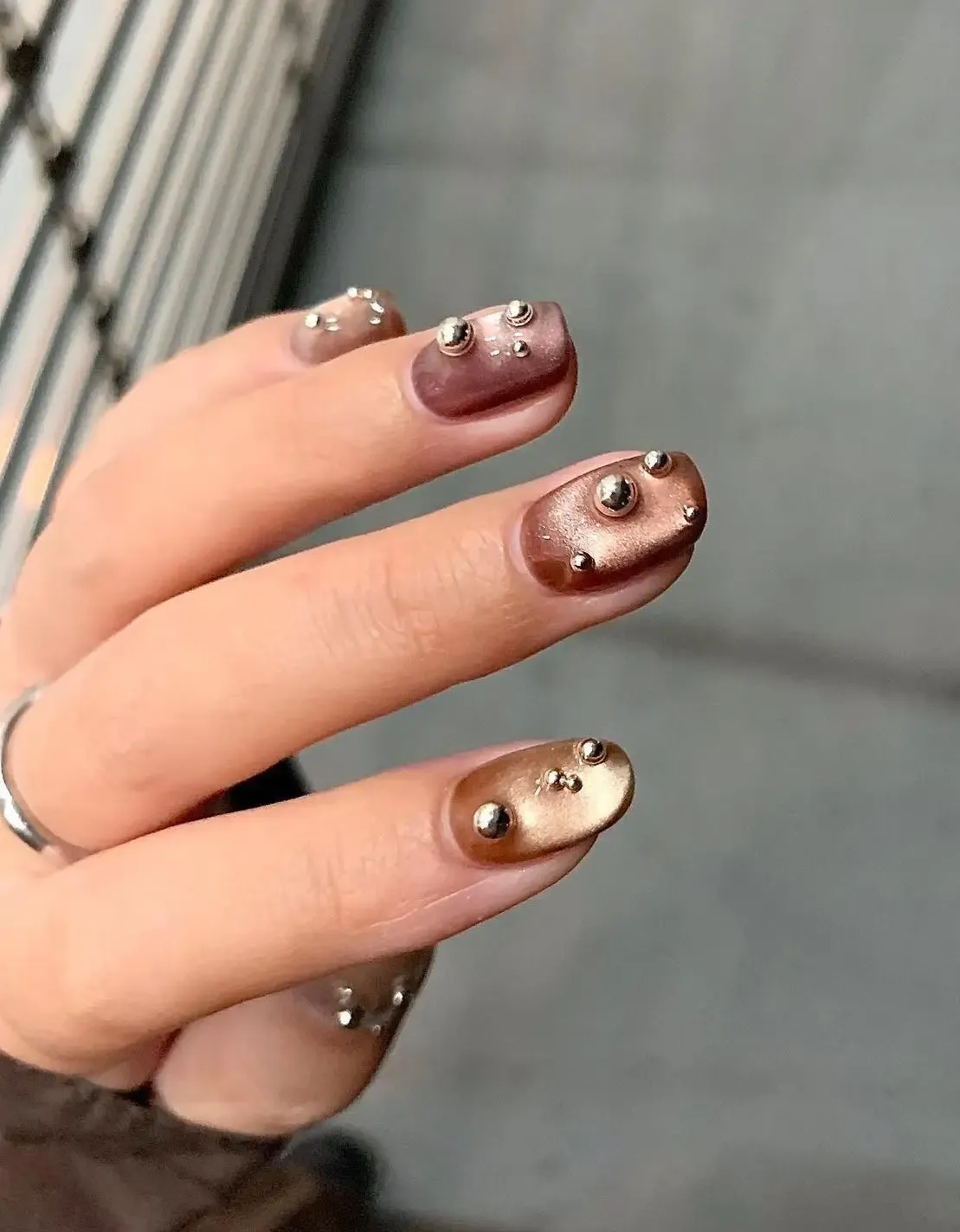 Brown velvet nails with metallic pearls.