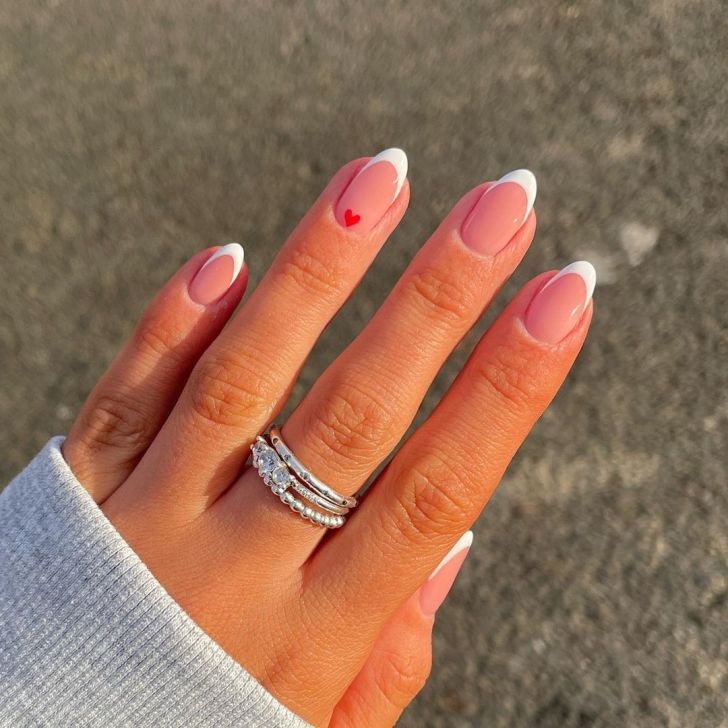 almond shaped white french tip simple Valentines Day nails with a cute red heart nail art accent design