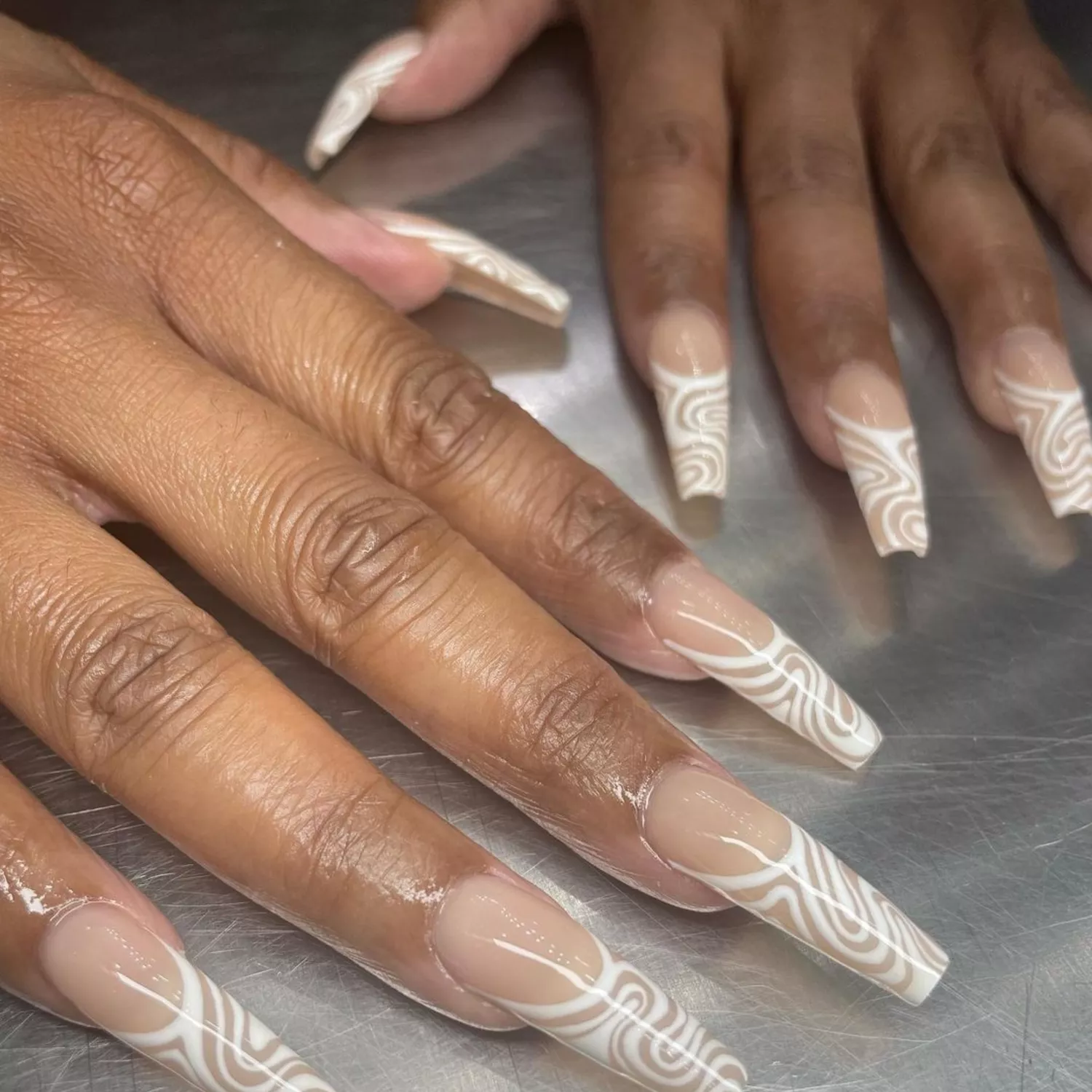 Long square-tipped nails with white swirl design