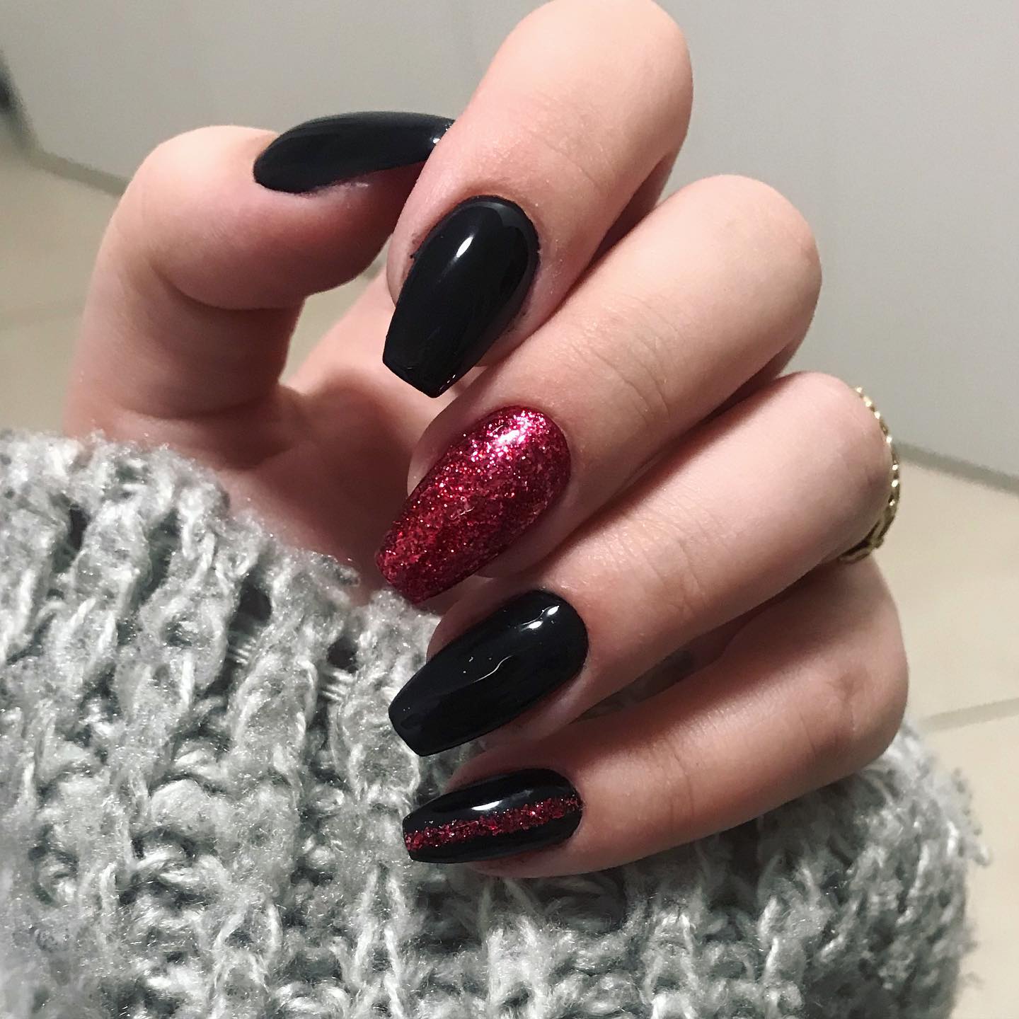 Glittered accent nails have always been a favourite one. If you think so, red glitters are here to make your nails shine. For your little finger, you can draw a red line on your black nail polish.