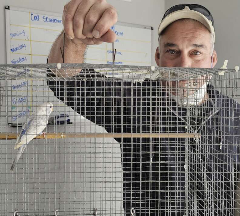 man holding birdcage