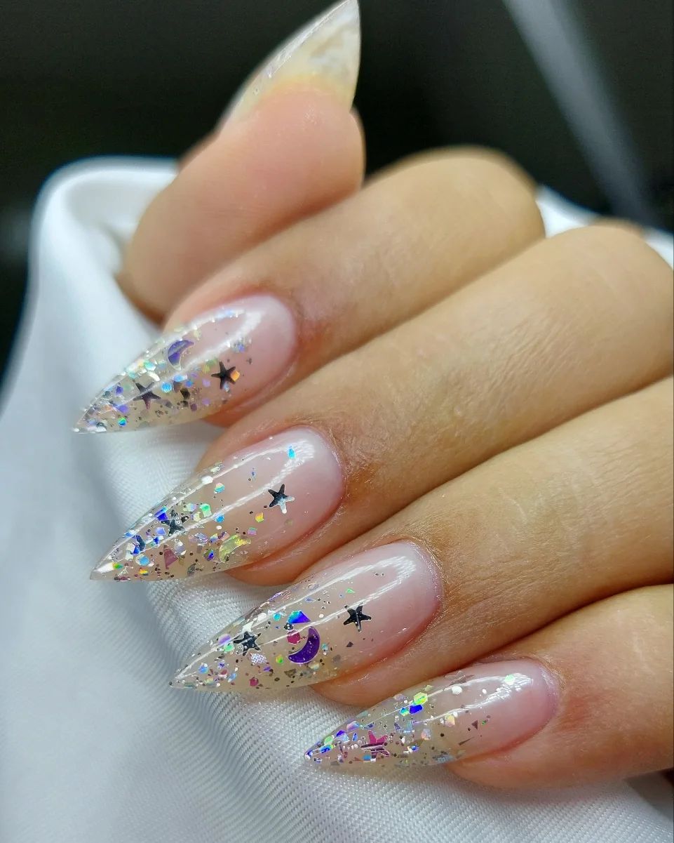 Here is a cute stiletto nail design. This glitter includes small stars, moons and some other pieces.