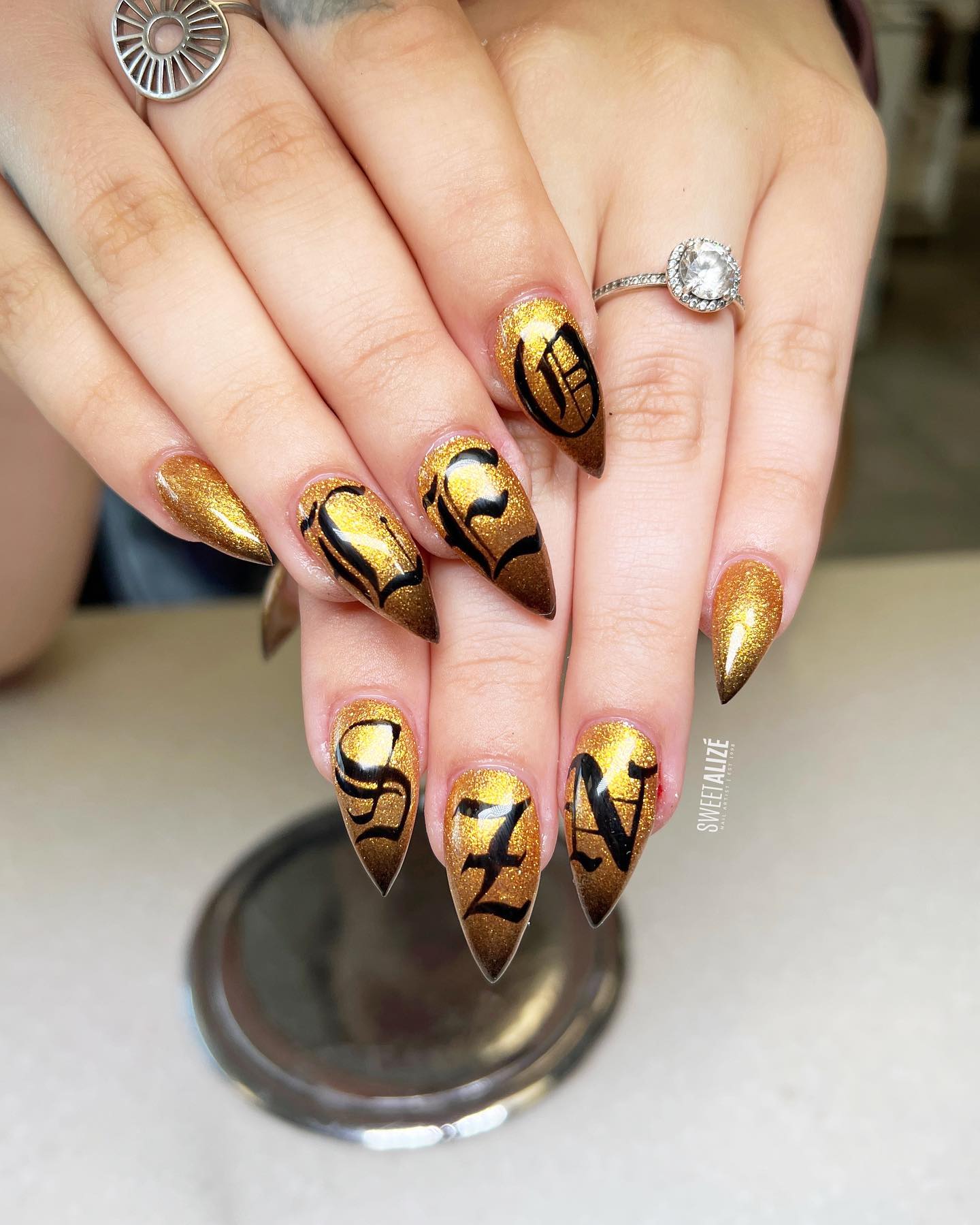 Shiny gold nail polish with all the letter nail art on it looks so rich, doesn't it? It gives the vibe that the person has a great taste.