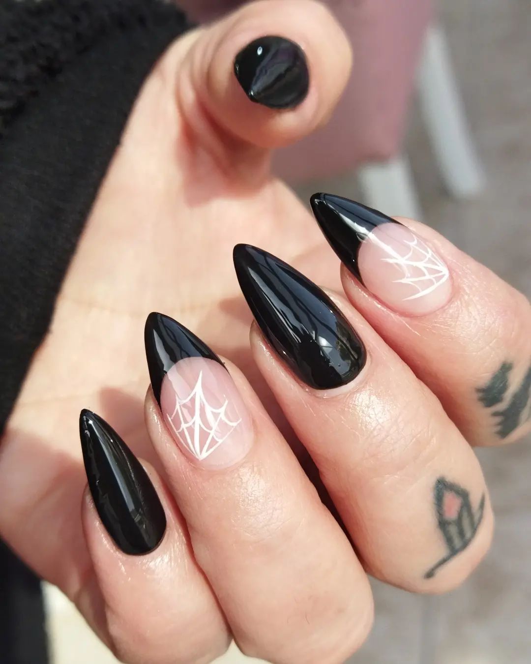 Shiny black stiletto nails are super cool. With these webs that are on black French nails, get ready to rock.