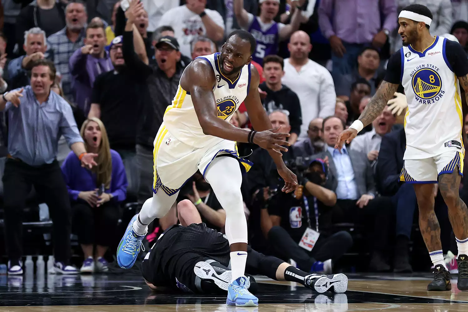 Draymond Green #23 of the Golden State Warriors steps over Domantas Sabonis #10 of the Sacramento Kings in the second half during Game Two of the Western Conference First Round Playoffs