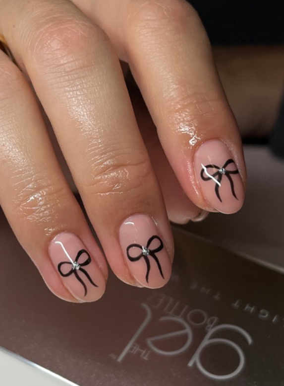 nude nails with black bows and silver gems