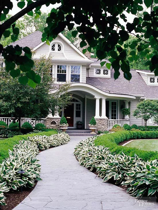 Front entrance to house, sidewalk lined with hostas and shrubs